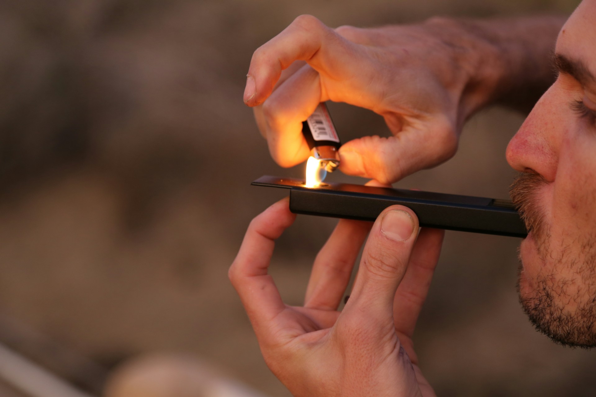 Man lights a bowl at twilight (photo by Smoke Honest)